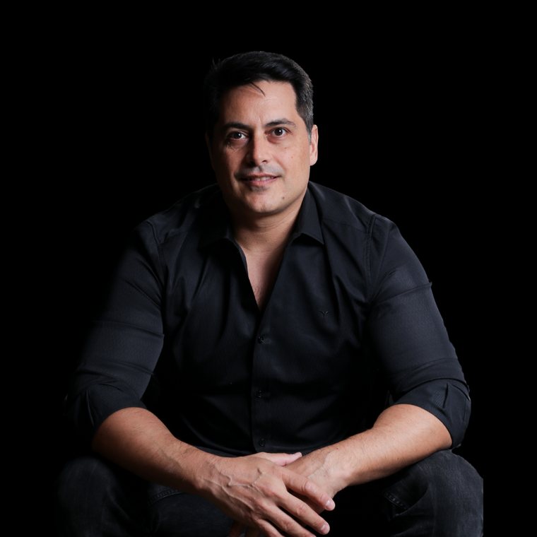 René Azzi, sentado, olhando para a câmera